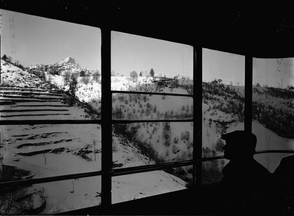 Finestra Vista Dall'Interno Con Uomini Che Osservano Le Montagne · Historify